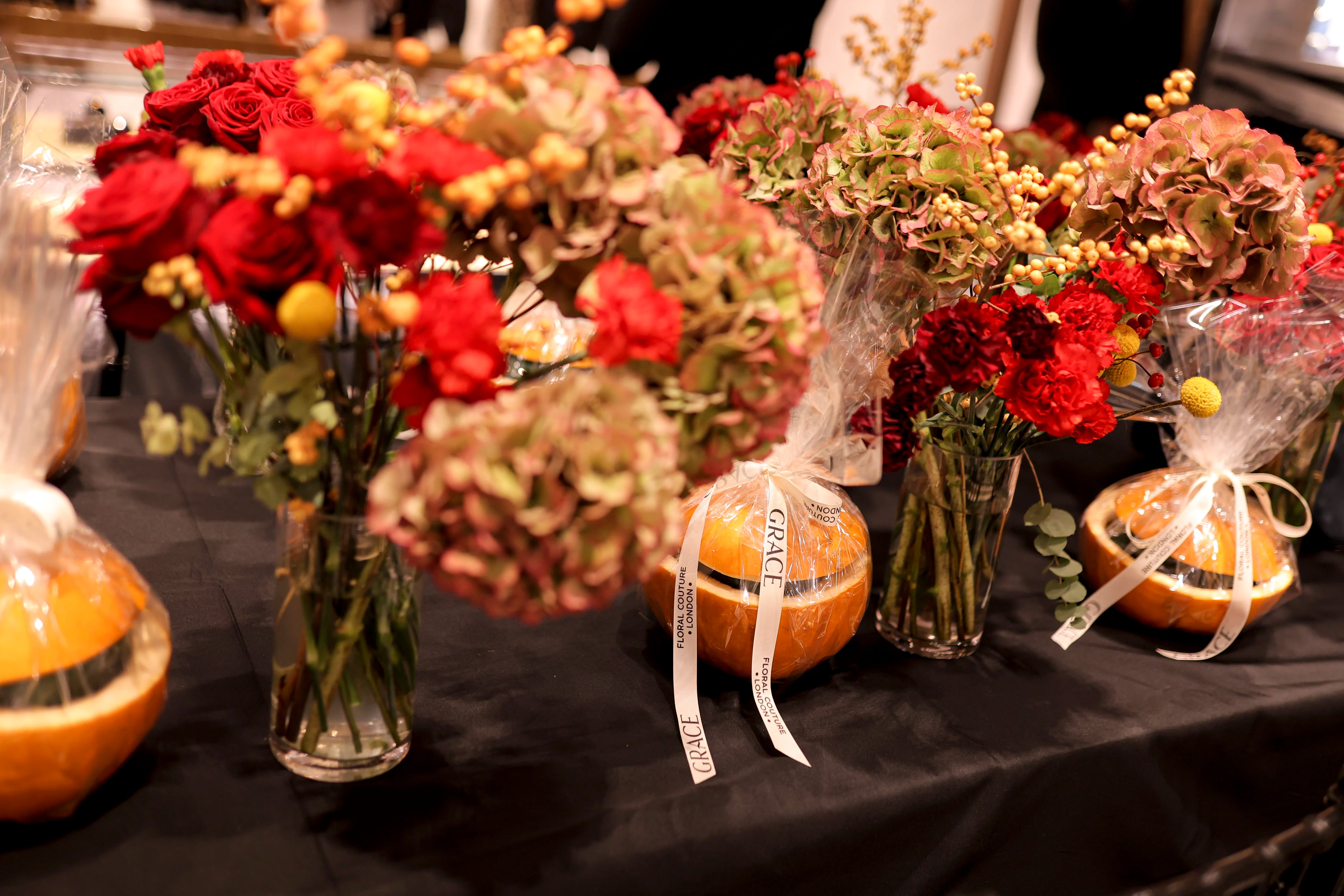 Decorative table with pumpkins, flowers, and decorative items on a black surface.