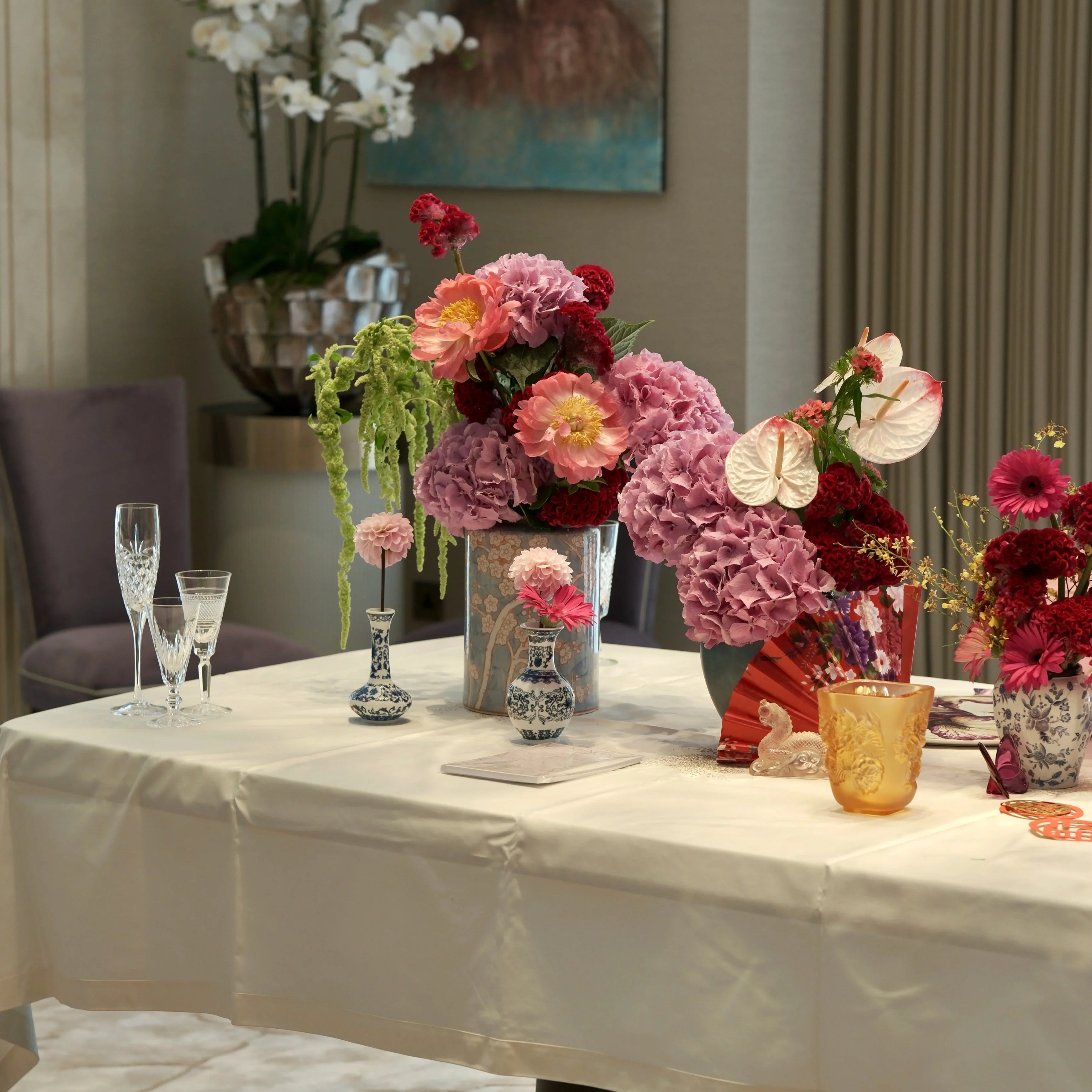 Decorative table setting with flowers and glasses in a room.